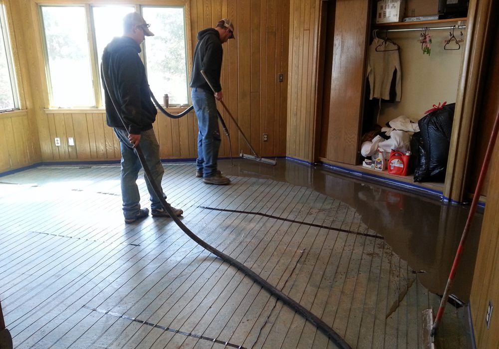 Self-leveling compound being poured over ThermaRay floor warming cable in Grand Marais, Minnesota
