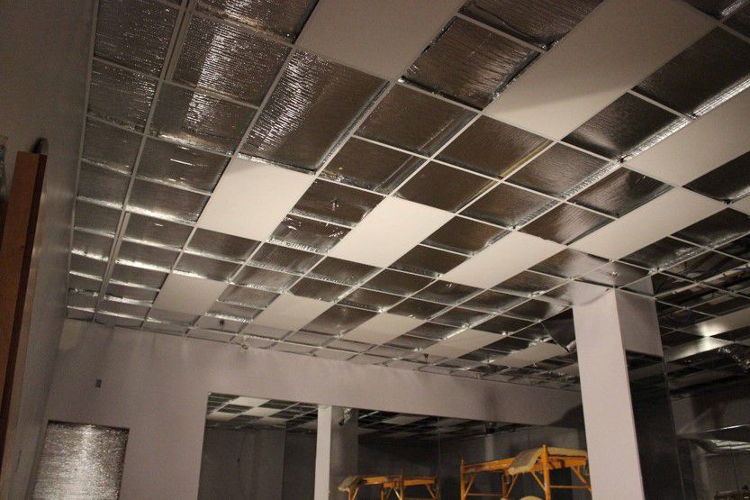Ceiling grid filled with foil-faced Architectural Series heaters during construction