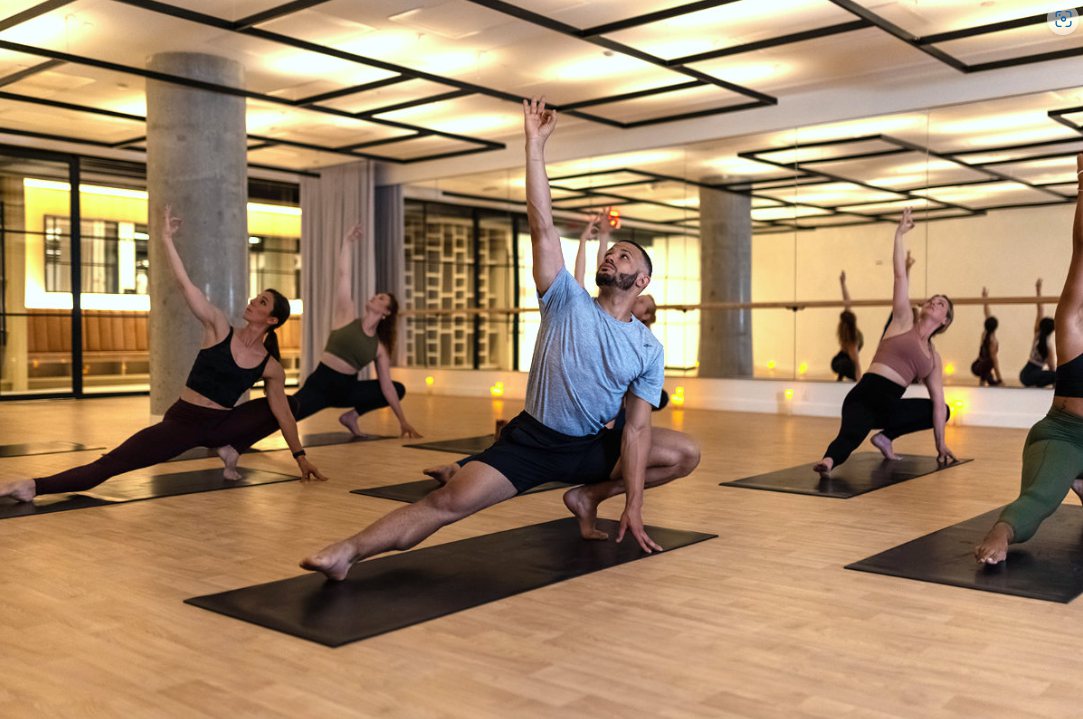 Yoga class at Performance Lab under the glowing Architectural Series heaters in the ceiling grid