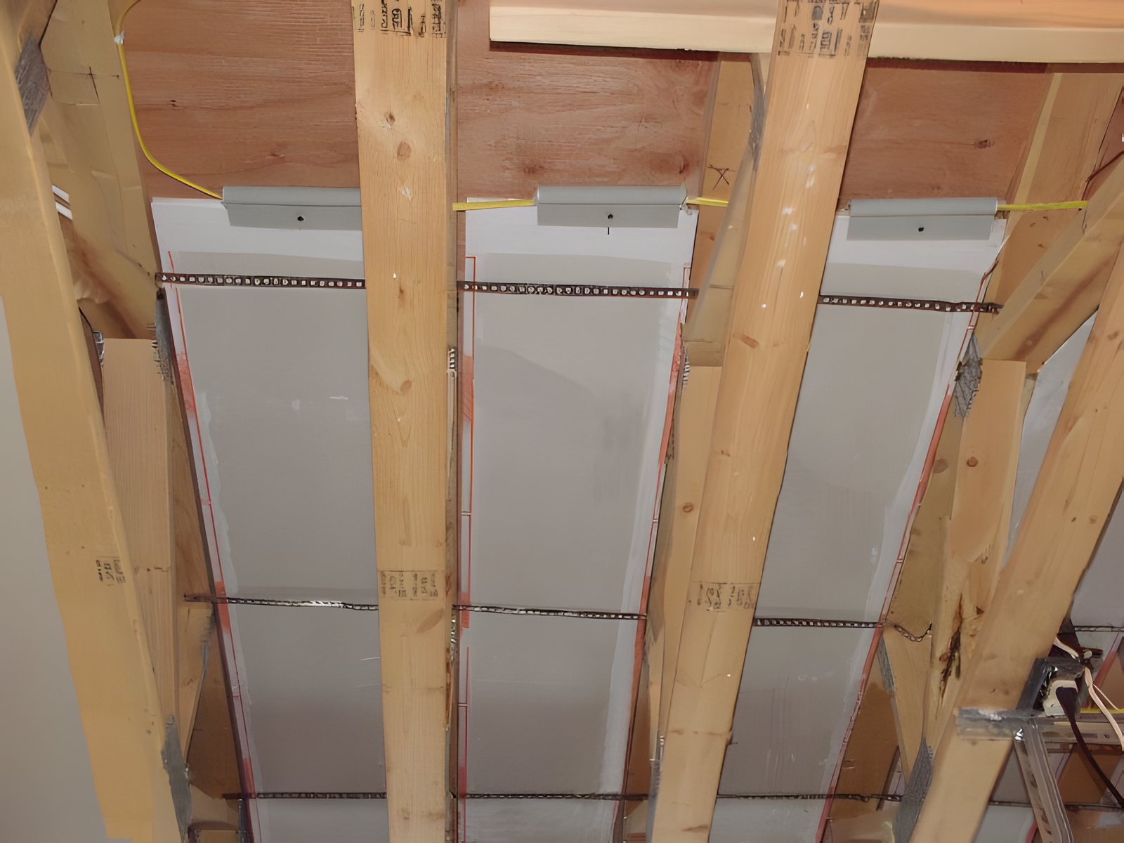 ThermaRay floor joist heating panels seen from below, mounted between floor joists