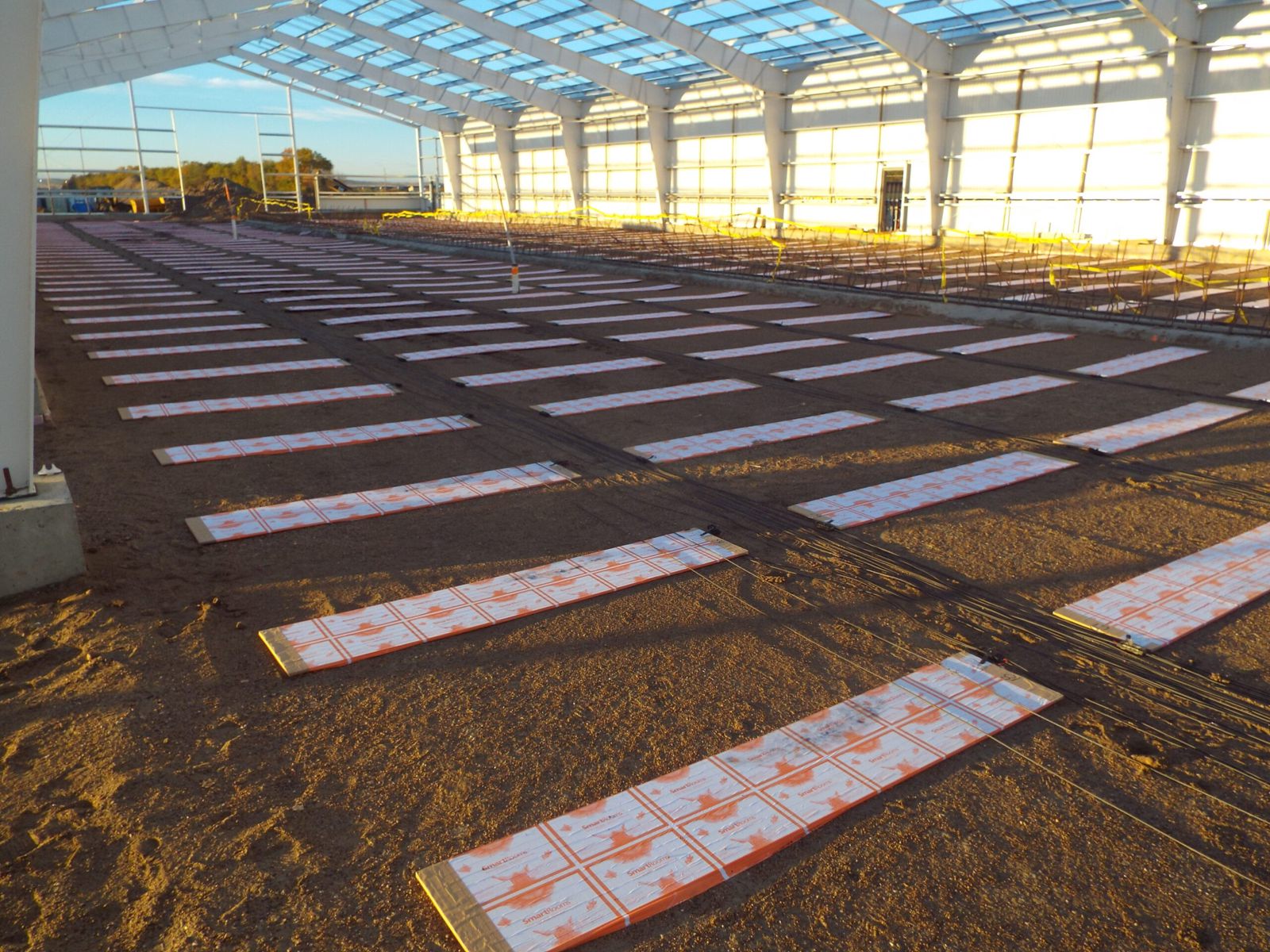 ThermaRay thermal mass heating panels laid out on sand before the slab is poured at McKenzie Electric Coop