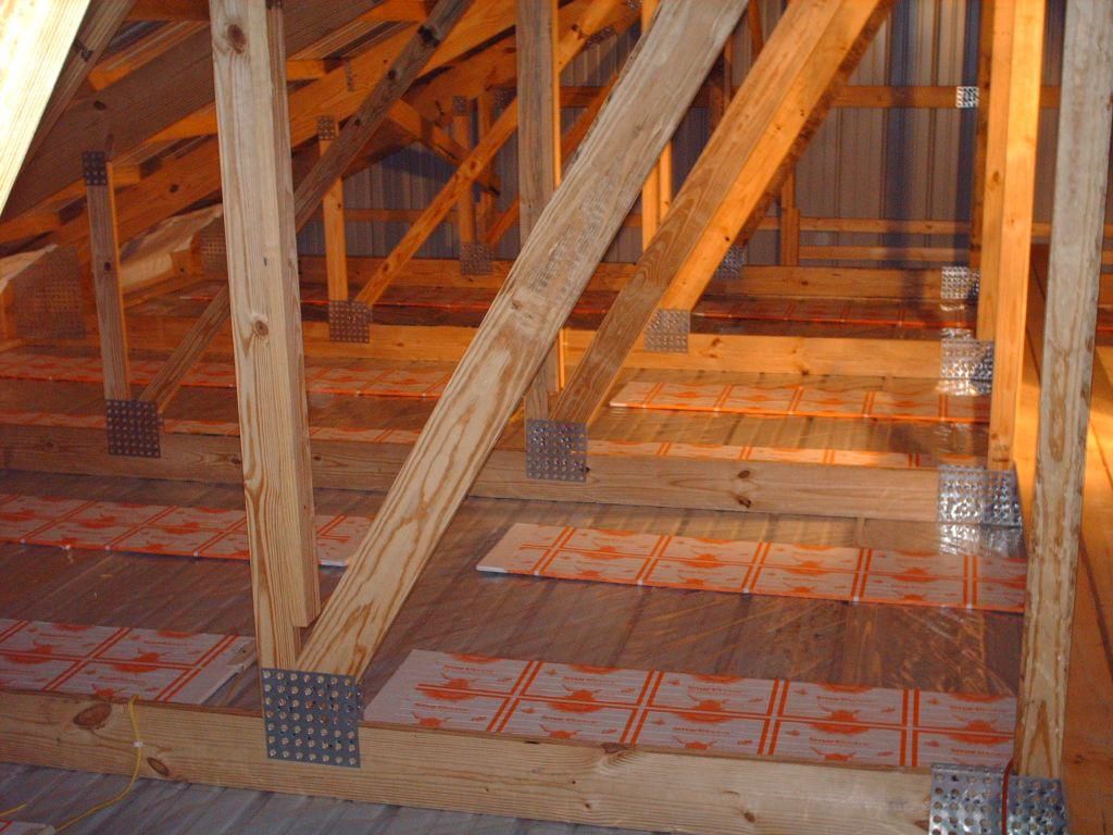 Radiant ceiling panels going in between wood trusses above a shop ceiling