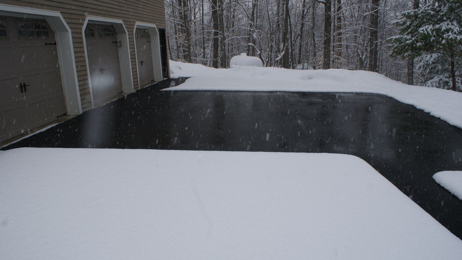 Snow melting system keeping a garage apron and driveway clear