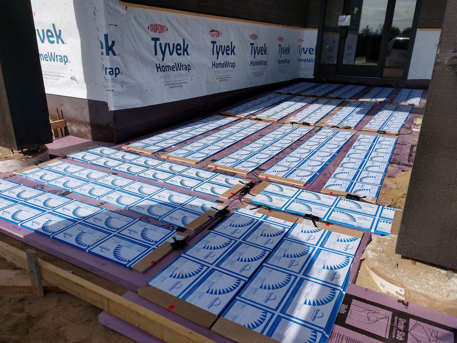 ThermaRay snow melting panels laid out before pavers are installed at a building entrance