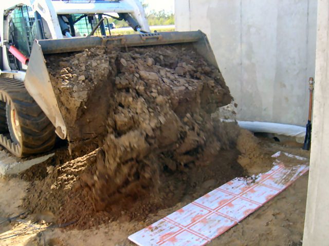 Sand being spread over ThermaRay thermal mass heating panels